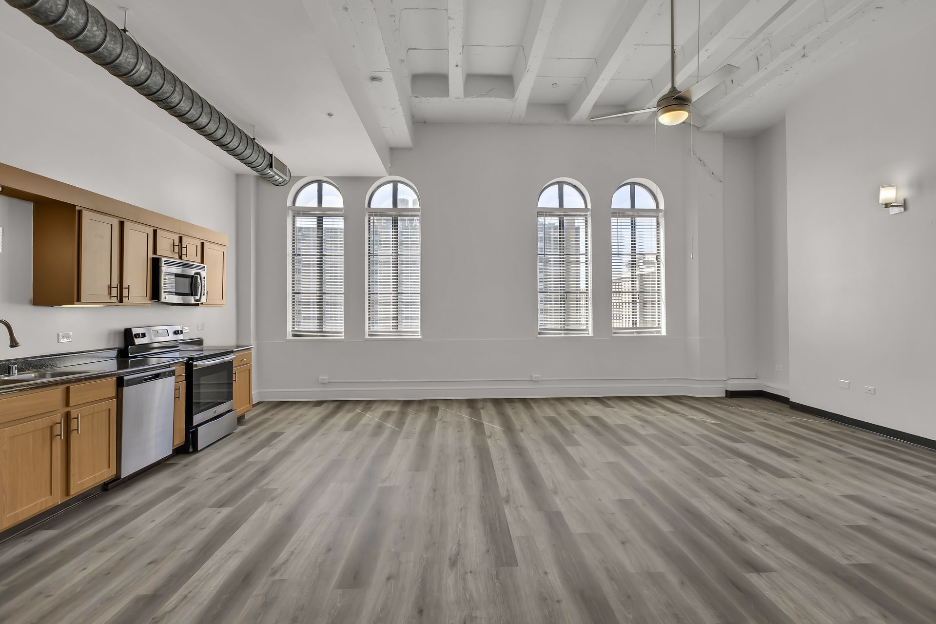 Large Loft 701 with three tall windows and an open kitchen, 1900 Elm Lofts